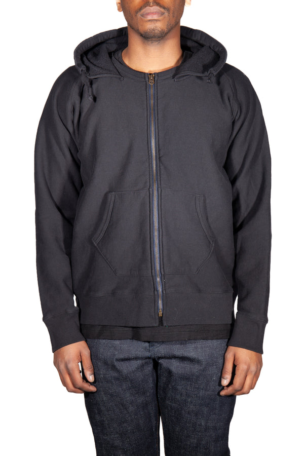 Person wearing a black zip-up hoodie on a white background