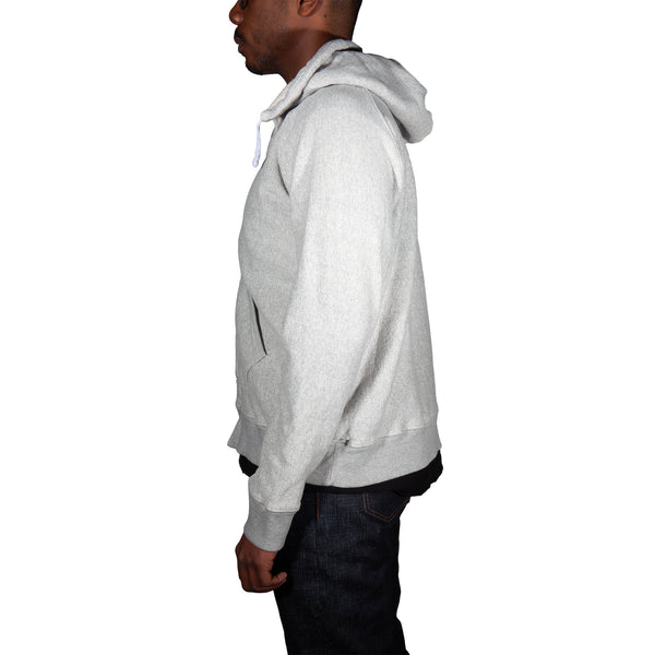Person wearing a gray hoodie on a white background