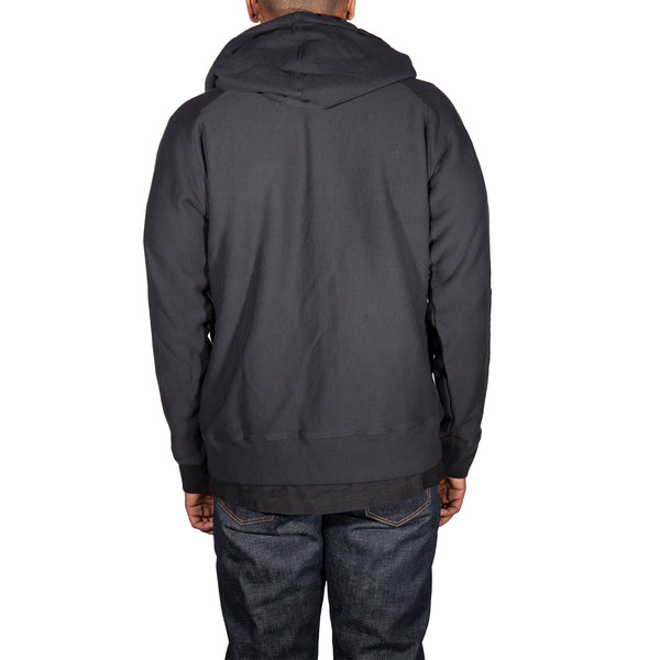 Person wearing a dark gray hoodie from behind on a white background