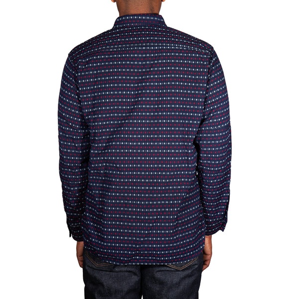 Person wearing a patterned shirt on a white background