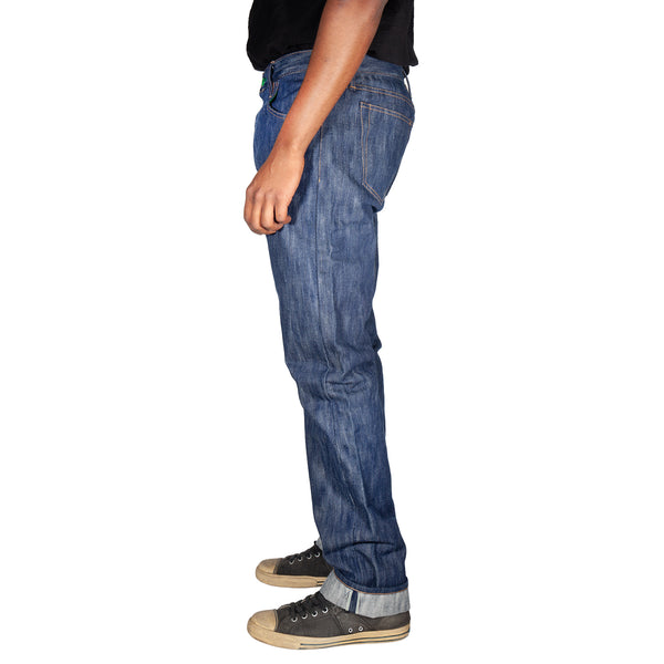 Person wearing blue jeans and black sneakers on a white background