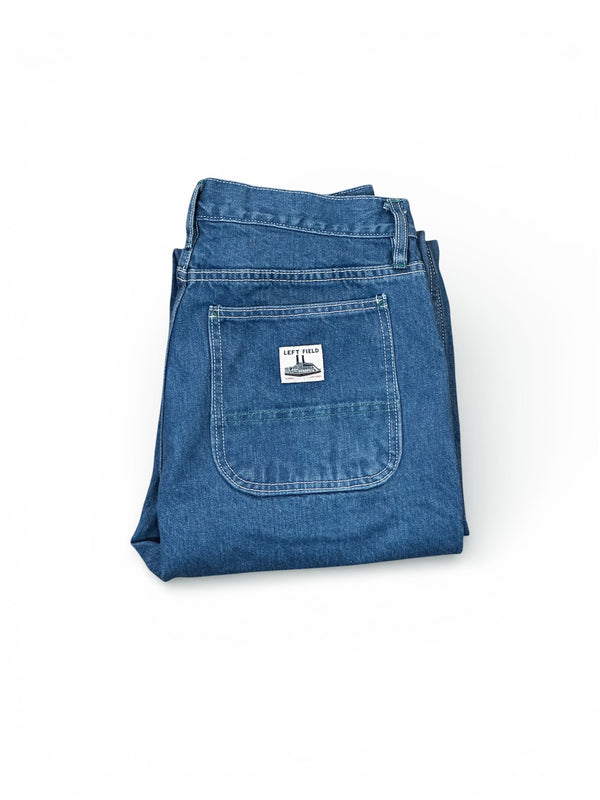 Folded blue denim jeans with a brand label on a white background