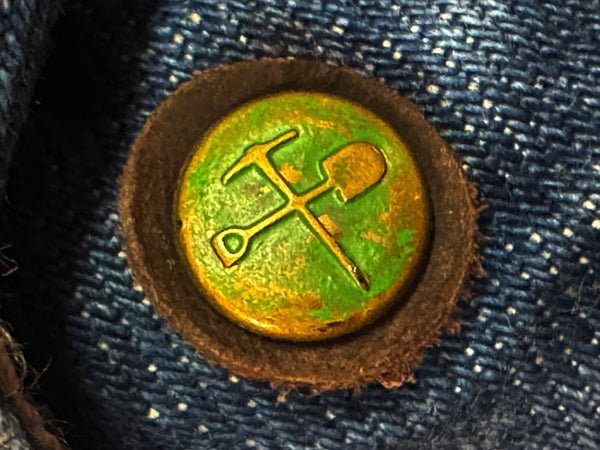 Decorative button with hammer and sickle symbol on a denim background