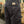 Dark pants with a brand label on the back pocket, worn by a person, in an indoor setting.