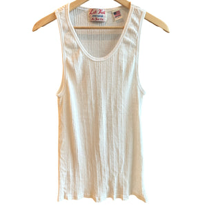 A white Japanese drop needle tank top with a slubby textured fabric, displayed on a wooden hanger.