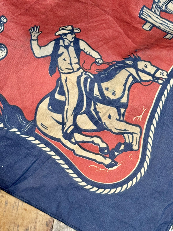 A red and blue bandana with a rotary print featuring horses cowboy and the brand 'Left Field'.