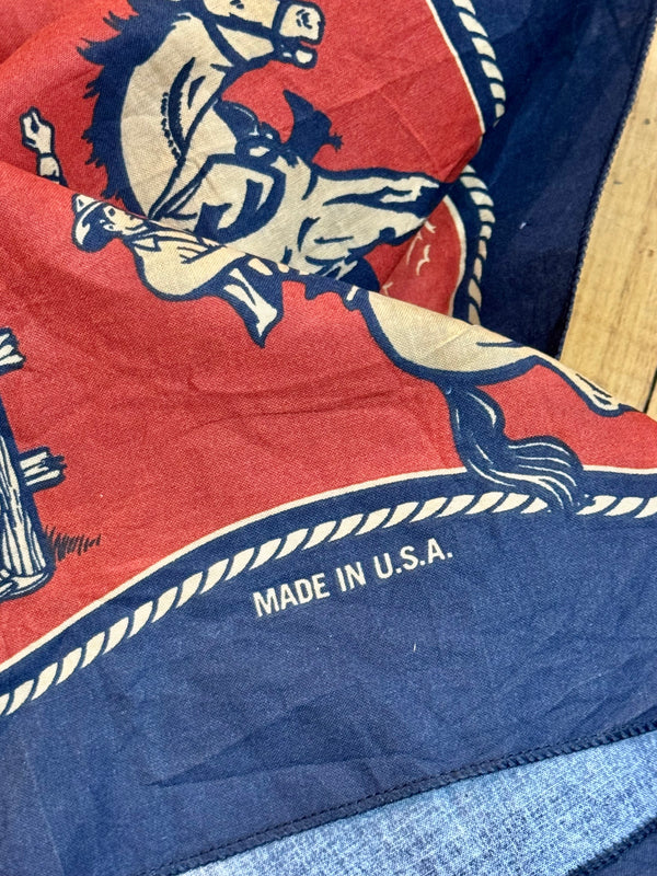 A red and blue bandana with a rotary print featuring horses cowboy and the brand 'Left Field'.