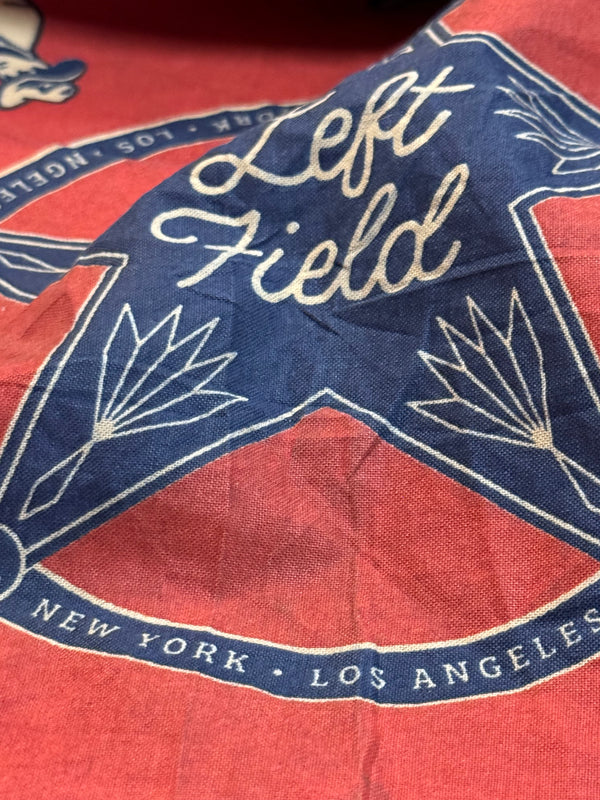 A red and blue bandana with a rotary print featuring horses cowboy and the brand 'Left Field'.