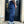 Person wearing blue jeans and black shoes standing in front of a door.