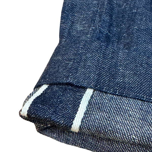 Close-up of blue denim fabric with white stitching on a white background