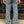 Person wearing hickory striped pants standing on a sidewalk 