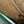 Close-up of a button on a brown fabric garment with visible stitching.