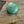 Green button with engraved text on a textured fabric background
