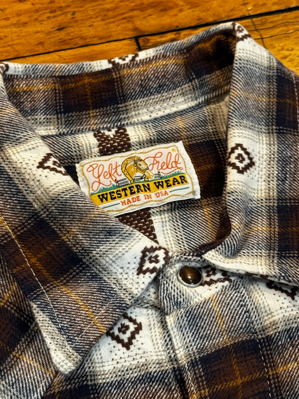 Plaid shirt with a visible label on a wooden surface