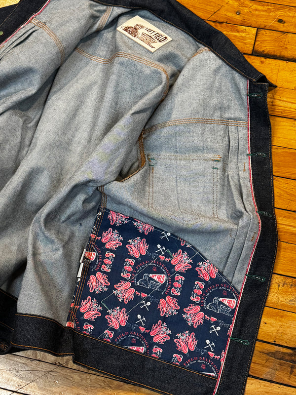 Pair of blue jeans with a floral patterned lining on a wooden floor.