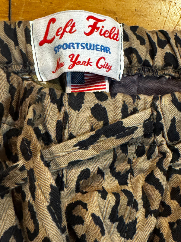 Close-up of a leopard print garment with a visible sewn-in label reading Left Field Sportsugar New York City.