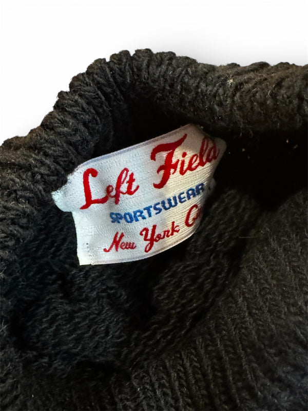 Close-up of a label on a dark knitted garment with 'Left Field Sportswear New York' text.