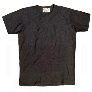A black crew neck t-shirt with a tag visible at the neckline, laid flat on a plain surface.