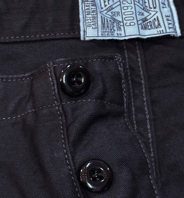 A pair of black chino trousers with front and back patch pockets
