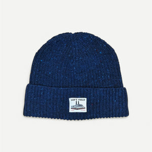 Blue knit beanie with a label on a light gray background