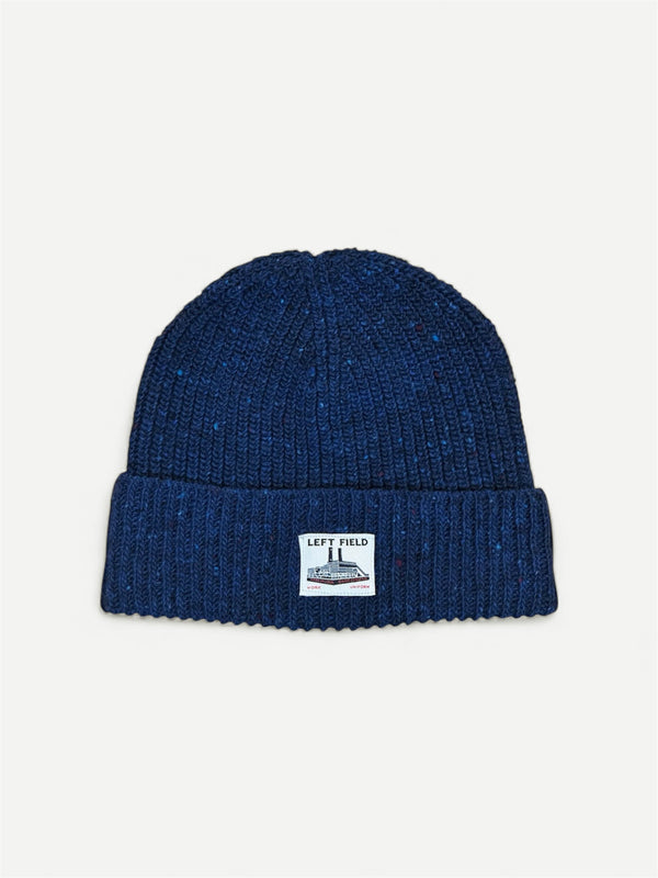Blue knit beanie with a label on a light gray background