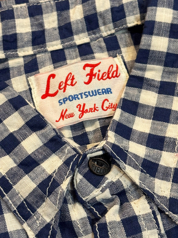 Close-up of a blue and white checkered shirt with a 'Left Field Sportswear New York City' label.