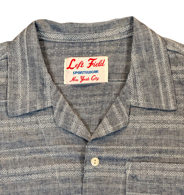A short-sleeved camp shirt with Trocus pearl buttons, collar, and a pocket on the chest, in a striped pattern.