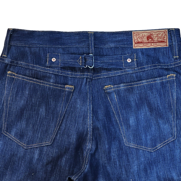 Close-up of blue jeans with a brand label on a white background