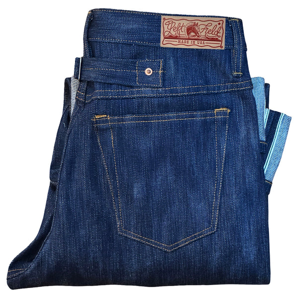 Folded pair of blue jeans with a brand label on a white background