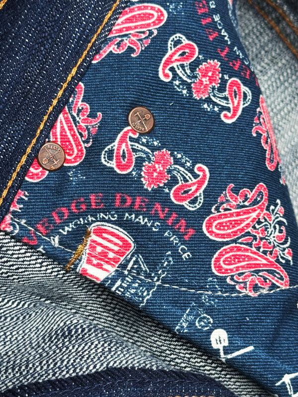 Close-up of denim fabric with red paisley pattern and 'Edge Denim' branding.