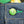 Green button with a logo on blue denim fabric