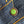 Close-up of a green button with a design on blue denim fabric.