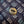 Bronze button with 'LEFT FIELD' text on a textured fabric background