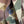 Close-up of a camouflage-patterned fabric garment with a dark button, showing shades of green, brown, tan, and beige.