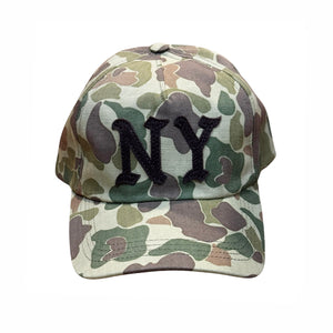 A baseball cap with a green, brown, and beige camouflage pattern, featuring a black embroidered 'NY' logo on the front, set against a plain white background.
