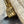 Close-up of a brass zipper pull with 'Talon' branding on a textured fabric background.