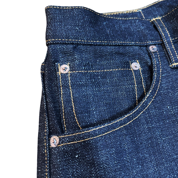Close-up of blue denim jeans with stitching details on a white background