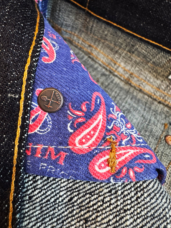 Close-up of a denim fabric with a paisley pattern pocketing and a bar tack.