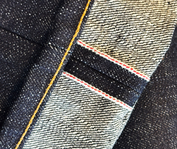 Close-up of denim fabric with red selvedge stitching 