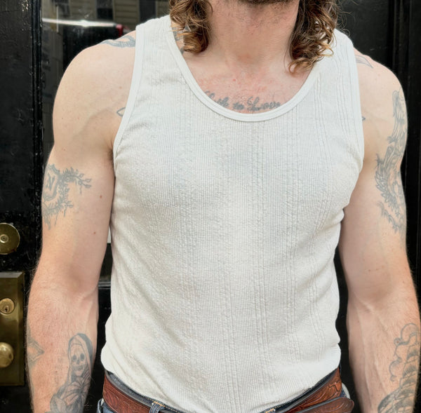 A white Japanese drop needle tank top with a slubby textured fabric,