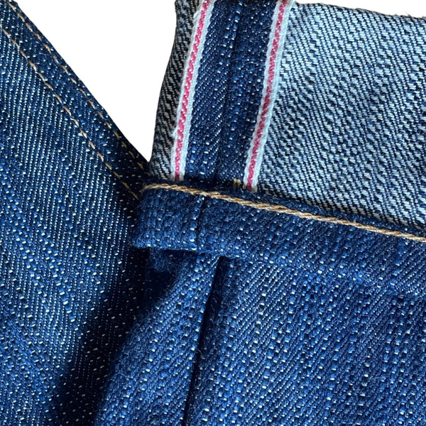 A pair of folded blue denim jeans with a label visible on the waistband.