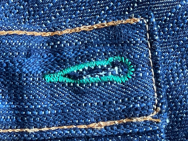 A pair of folded blue denim jeans with a label visible on the waistband.