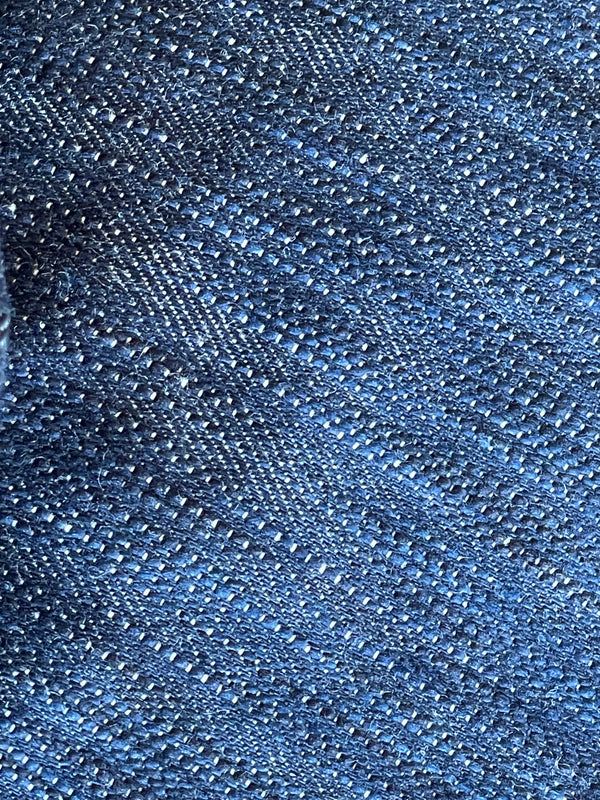 A pair of folded blue denim jeans with a label visible on the waistband.