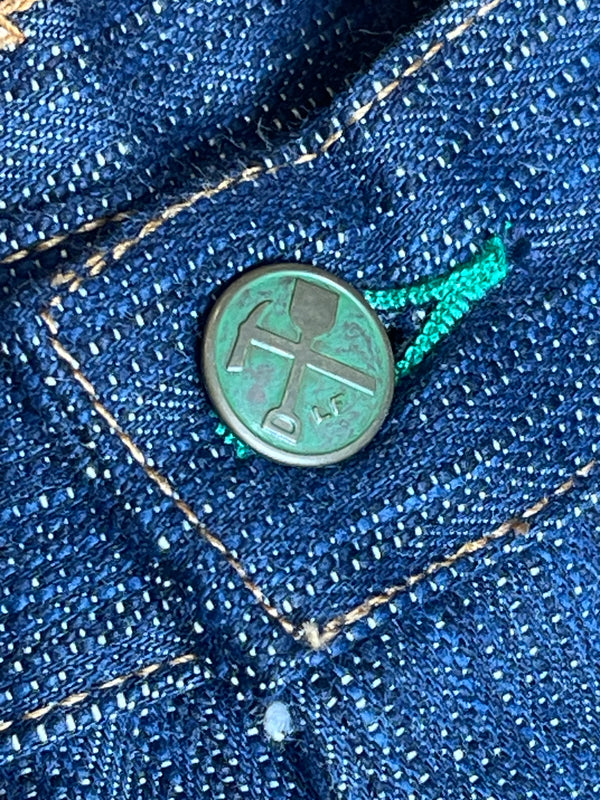 A pair of folded blue denim jeans with a label visible on the waistband.