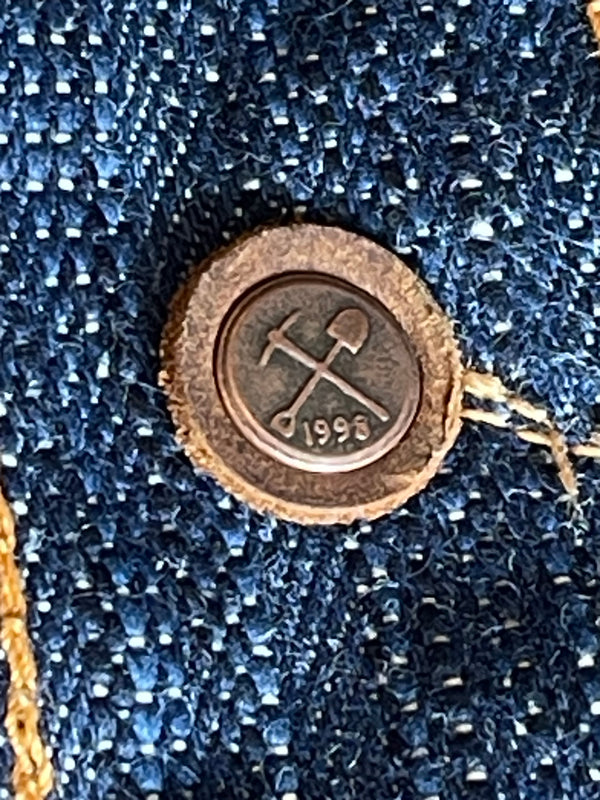 A pair of folded blue denim jeans with a label visible on the waistband.