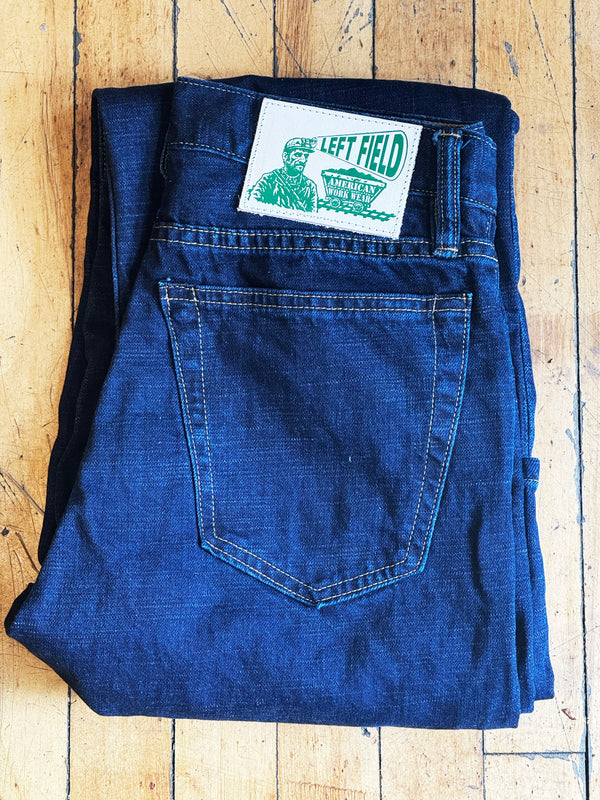 Folded blue jeans with a brand label on a wooden surface