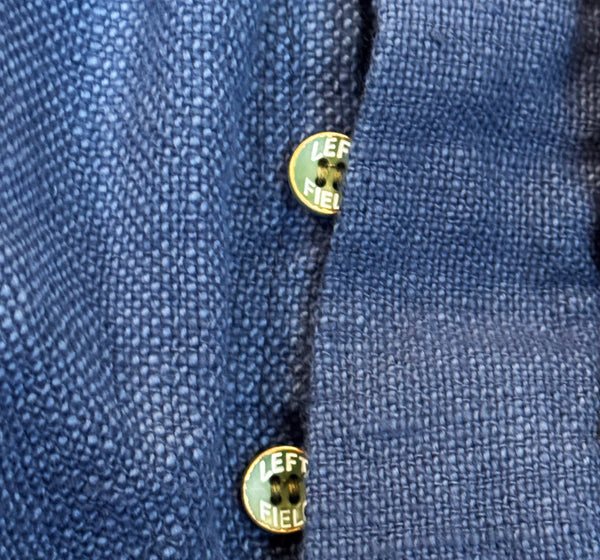 Close-up of a blue textured fabric with two buttons on a white background