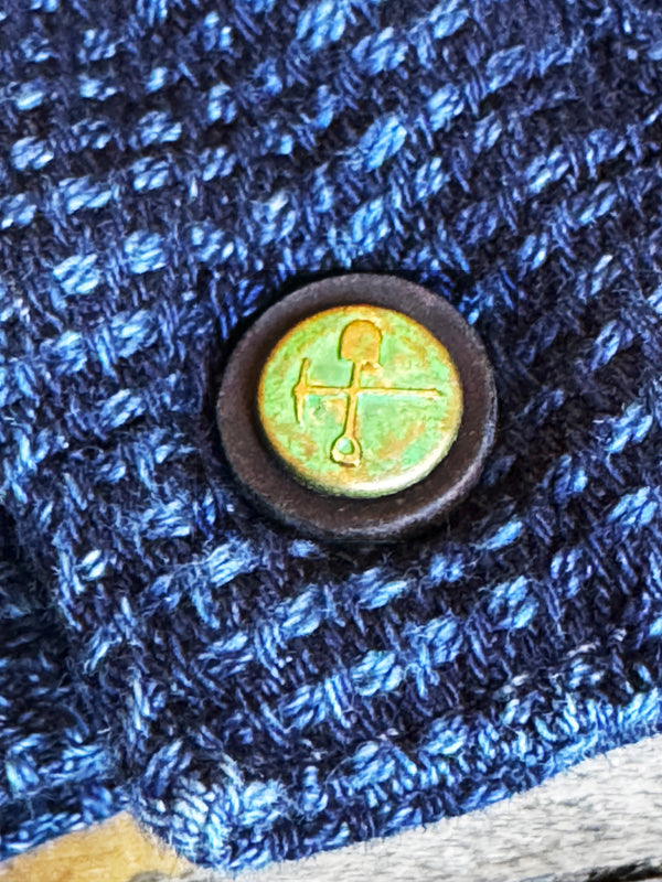 Close-up of a button on blue textured fabric