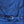 Close-up of a blue fabric with a buckle and buttons on a wooden surface