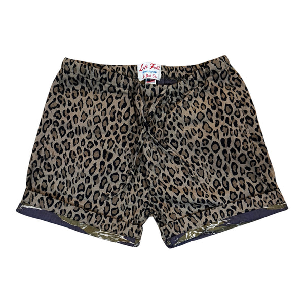 A pair of leopard print shorts with a tan, brown, and black pattern, featuring a white brand label that reads 'La Tuta' on the inside waistband, shown against a plain white background.